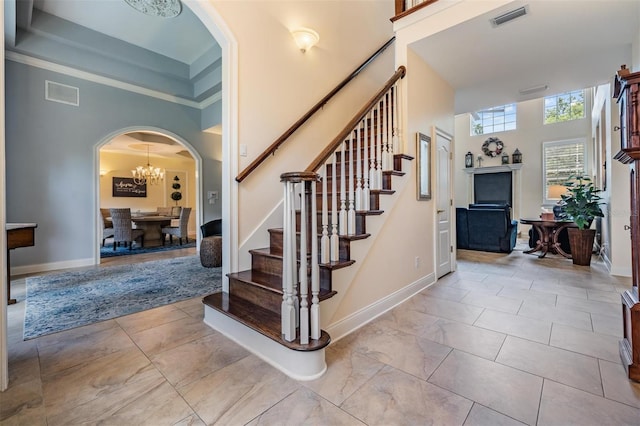 2880 Chelsea Pl N, Clearwater, FL 33759 - stairway with a towering ceiling, arched walkways, and a chandelier