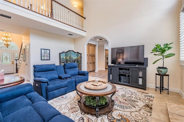 2880 Chelsea Pl N, Clearwater, FL 33759 - living area with a towering ceiling, arched walkways, a chandelier, and light tile patterned flooring