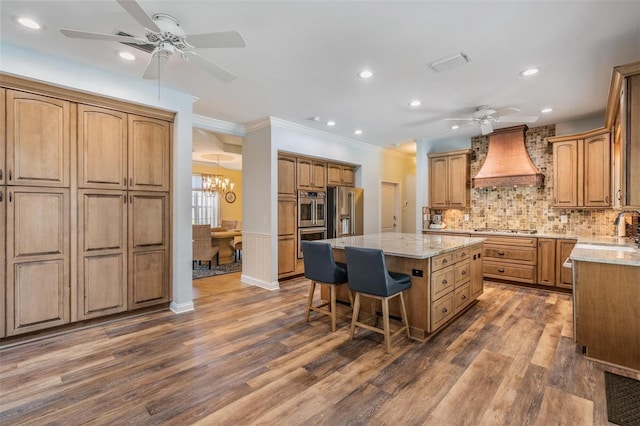 2880 Chelsea Pl N, Clearwater, FL 33759 - kitchen with a ceiling fan, custom exhaust hood, appliances with stainless steel finishes, crown molding, and a center island