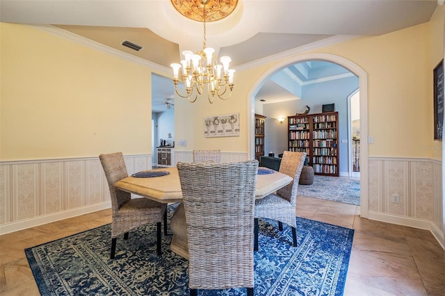 2880 Chelsea Pl N, Clearwater, FL 33759 - dining room featuring a wainscoted wall, arched walkways, a chandelier, and crown molding