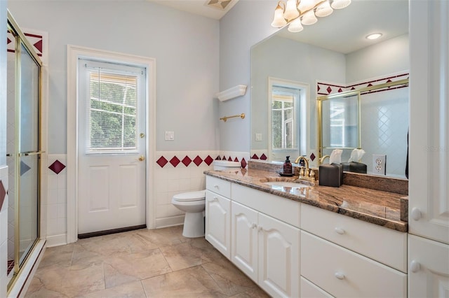 2880 Chelsea Pl N, Clearwater, FL 33759 - bathroom with vanity, tile walls, a stall shower, and wainscoting