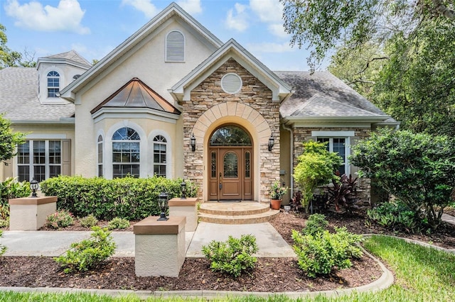 2880 Chelsea Pl N, Clearwater, FL 33759 - view of front facade with stone siding, stucco siding, and roof with shingles