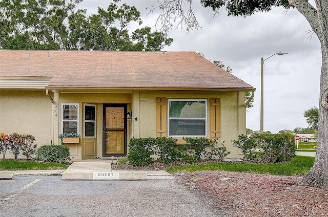 10670 43rd St N Unit 204, Clearwater, FL 33762 - view of front facade featuring stucco siding and a shingled roof