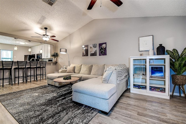 10670 43rd St N Unit 204, Clearwater, FL 33762 - living room with ceiling fan, wood finished floors, vaulted ceiling, and a textured ceiling