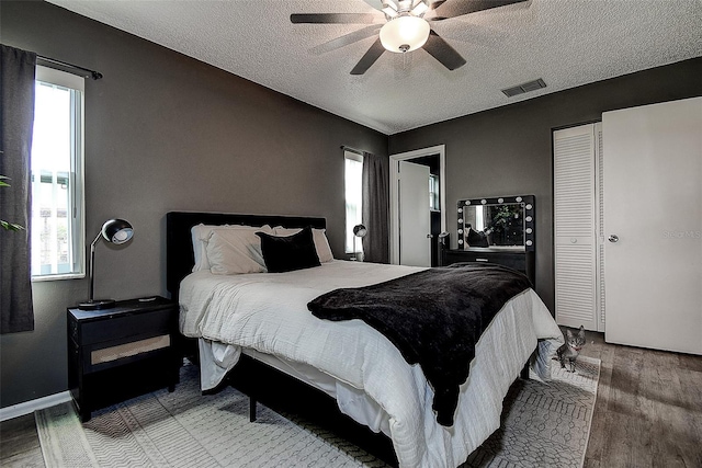 10670 43rd St N Unit 204, Clearwater, FL 33762 - bedroom with wood finished floors, multiple windows, a textured ceiling, and ceiling fan