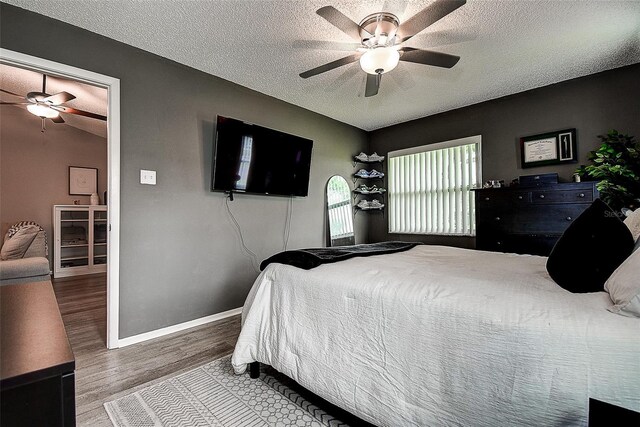 10670 43rd St N Unit 204, Clearwater, FL 33762 - bedroom featuring a textured ceiling, wood finished floors, baseboards, and ceiling fan