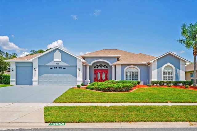 10250 Locker Dr, Spring Hill, FL 34608 - mediterranean / spanish house with a garage, a front yard, stucco siding, and driveway