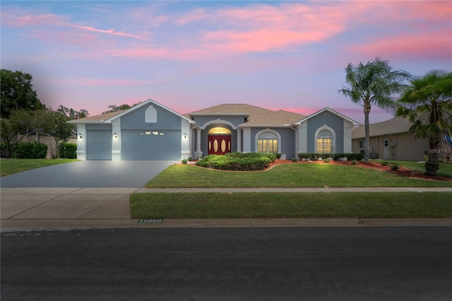 10250 Locker Dr, Spring Hill, FL 34608 - view of front facade featuring a garage, a front yard, driveway, and stucco siding