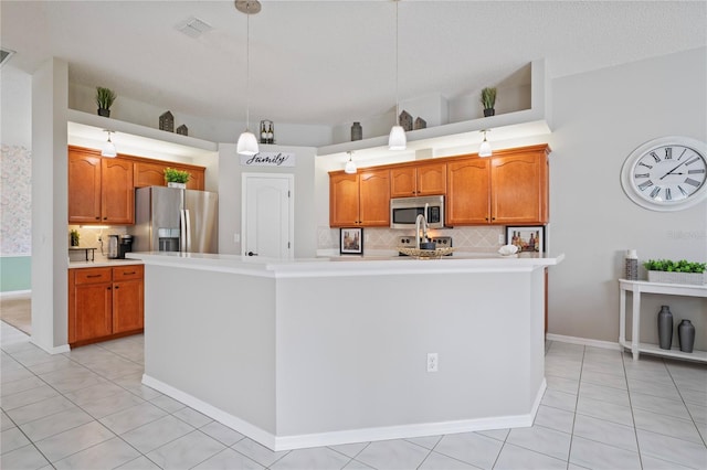10250 Locker Dr, Spring Hill, FL 34608 - kitchen featuring appliances with stainless steel finishes, light countertops, decorative backsplash, a kitchen island with sink, and brown cabinets