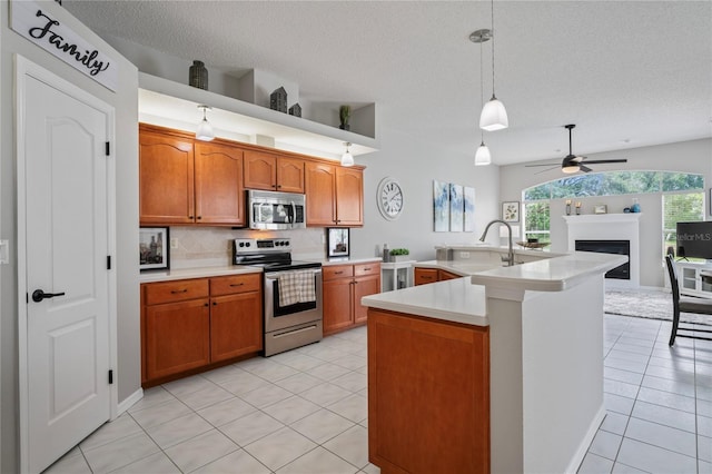 10250 Locker Dr, Spring Hill, FL 34608 - kitchen featuring appliances with stainless steel finishes, ceiling fan, light countertops, a fireplace, and a textured ceiling