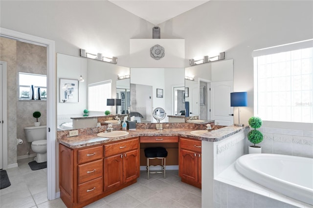 10250 Locker Dr, Spring Hill, FL 34608 - full bathroom featuring toilet, tile patterned floors, a garden tub, double vanity, and a towering ceiling
