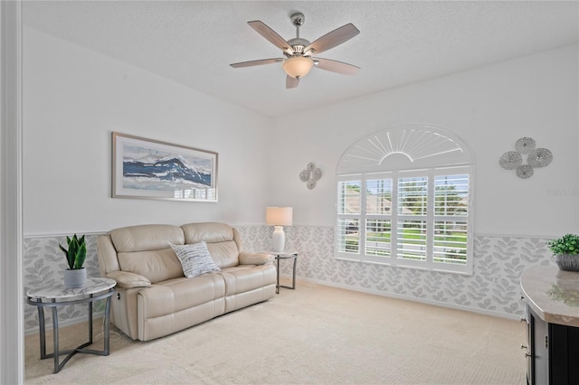 10250 Locker Dr, Spring Hill, FL 34608 - living room with carpet, a ceiling fan, wallpapered walls, wainscoting, and a textured ceiling