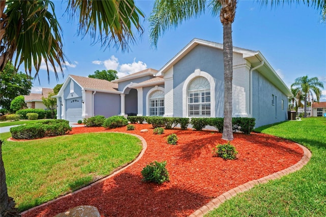 10250 Locker Dr, Spring Hill, FL 34608 - view of front of house with a garage, a front yard, and stucco siding