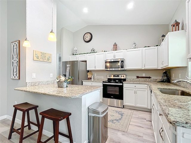 12396 SW 64th Street Rd, Ocala, FL 34481 - kitchen with stainless steel appliances, a peninsula, a kitchen breakfast bar, light stone countertops, and white cabinetry