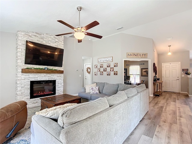 12396 SW 64th Street Rd, Ocala, FL 34481 - living room featuring a ceiling fan, light wood-style flooring, a fireplace, and high vaulted ceiling