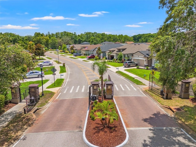 11579 Weaver Hollow Rd, New Port Richey, FL 34654 - view of asphalt street with a residential view, sidewalks, street lights, curbs, and a gate
