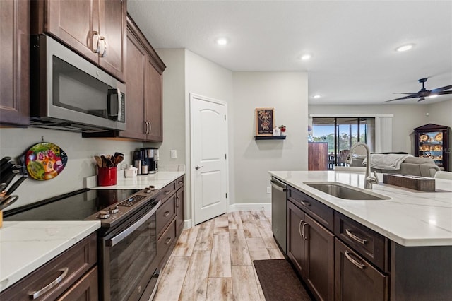 11579 Weaver Hollow Rd, New Port Richey, FL 34654 - kitchen with appliances with stainless steel finishes, a sink, light wood finished floors, recessed lighting, and open floor plan