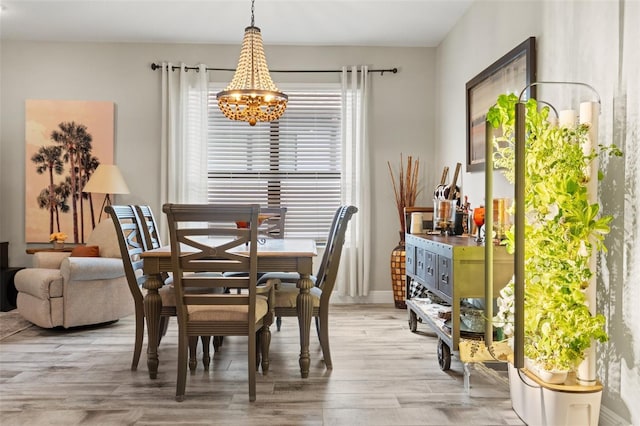 11579 Weaver Hollow Rd, New Port Richey, FL 34654 - dining space featuring a chandelier and light wood-style floors