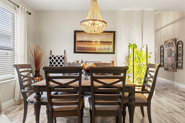 11579 Weaver Hollow Rd, New Port Richey, FL 34654 - dining room featuring baseboards, a chandelier, plenty of natural light, and light wood-style floors