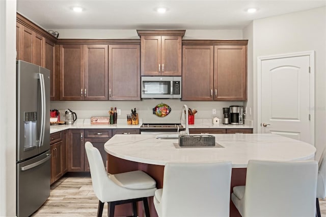 11579 Weaver Hollow Rd, New Port Richey, FL 34654 - kitchen featuring appliances with stainless steel finishes, a breakfast bar area, recessed lighting, a sink, and a kitchen island with sink