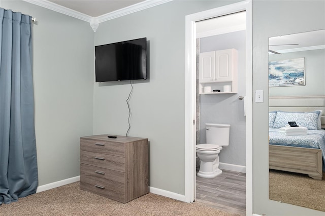 4851 NE 7th St, Ocala, FL 34470 - bedroom featuring crown molding, baseboards, carpet flooring, and connected bathroom