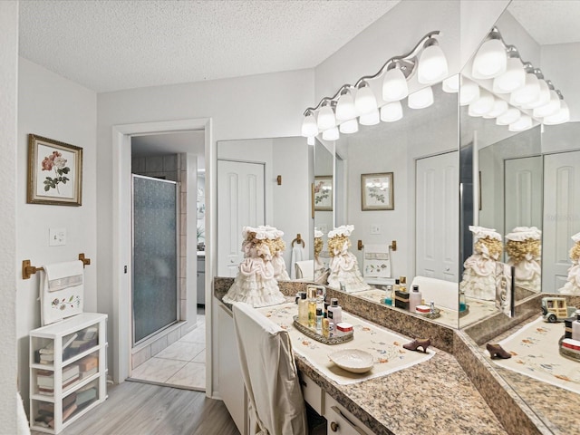 3832 Sailmaker Ln Unit 3832, Holiday, FL 34691 - full bath featuring a shower stall, wood finished floors, vanity, a textured ceiling, and a closet