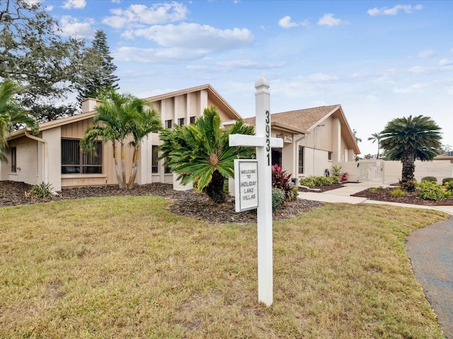 3832 Sailmaker Ln Unit 3832, Holiday, FL 34691 - mid-century modern home featuring a chimney and a gate