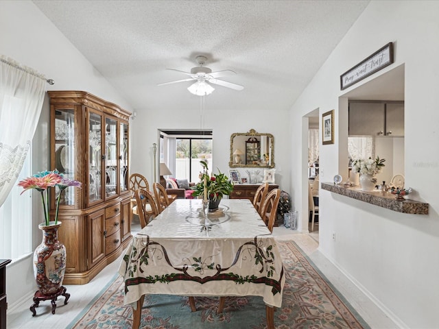 3832 Sailmaker Ln Unit 3832, Holiday, FL 34691 - dining area featuring vaulted ceiling, a textured ceiling, a ceiling fan, and baseboards