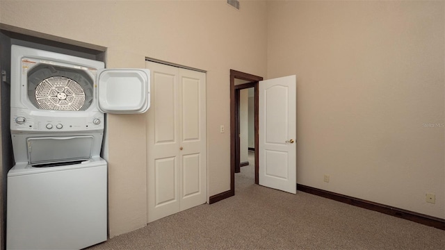 6322 Aureau Ave, Hudson, FL 34667 - laundry area with estacked washer and dryer, carpet floors, and baseboards