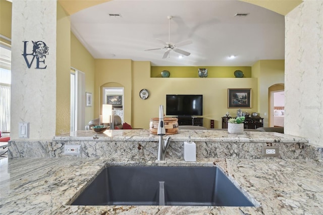 11637 Spindrift Loop, Hudson, FL 34667 - kitchen with a ceiling fan, arched walkways, open floor plan, and light stone counters