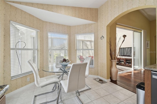 11637 Spindrift Loop, Hudson, FL 34667 - dining space featuring arched walkways, wallpapered walls, and light tile patterned flooring