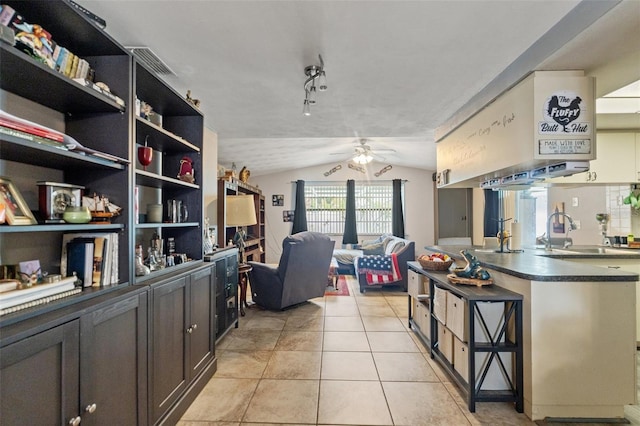4350 Sawgrass Blvd, New Port Richey, FL 34653 - kitchen featuring lofted ceiling, a ceiling fan, dark countertops, light tile patterned floors, and a sink