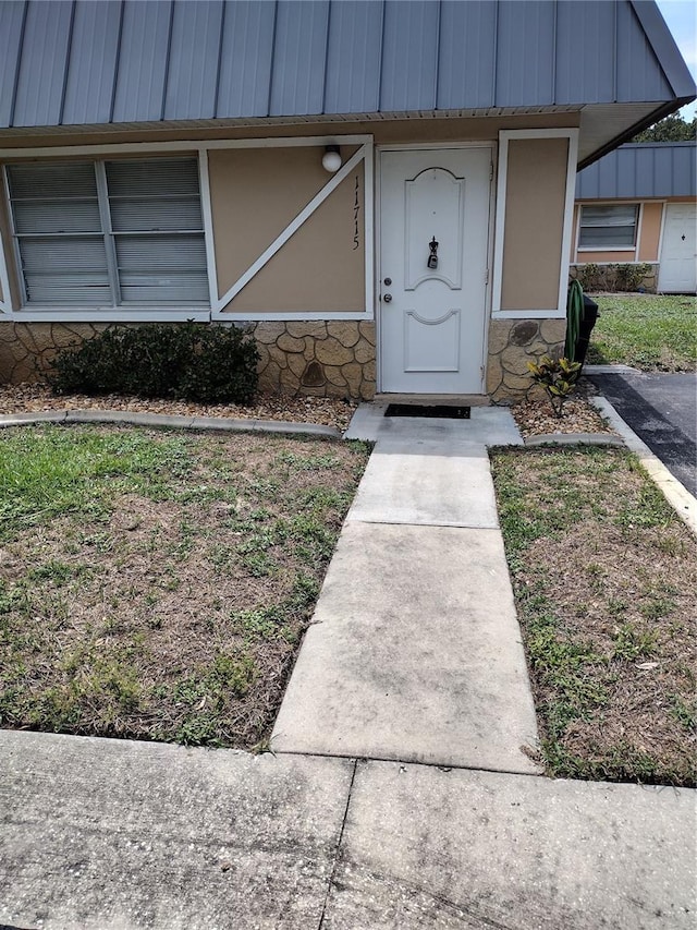 11715 Boynton Ln Unit 74B, New Port Richey, FL 34654 - doorway to property with stone siding