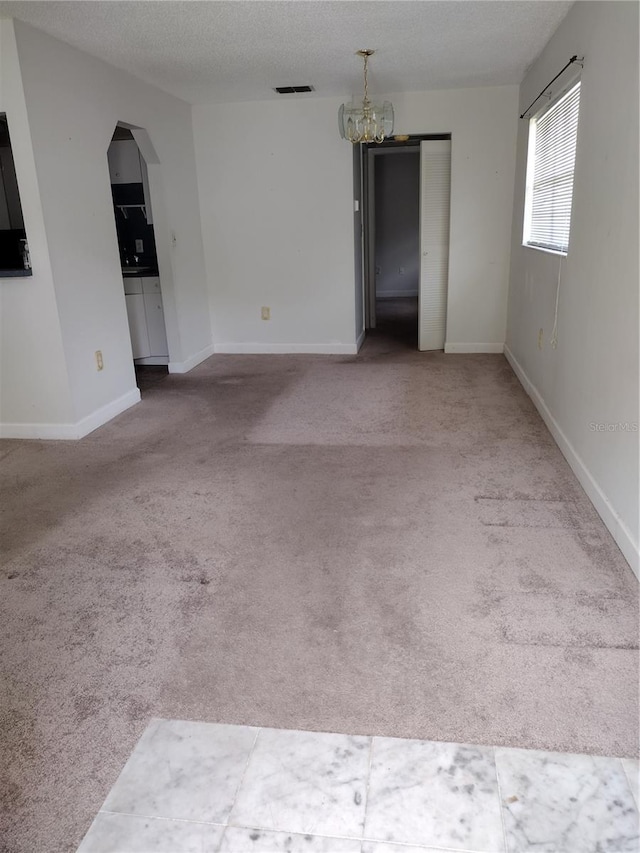 11715 Boynton Ln Unit 74B, New Port Richey, FL 34654 - empty room with a chandelier, carpet, arched walkways, and baseboards