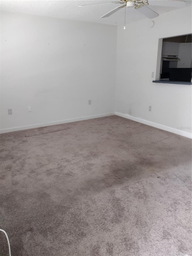 11715 Boynton Ln Unit 74B, New Port Richey, FL 34654 - unfurnished room with ceiling fan, carpet flooring, baseboards, and a textured ceiling