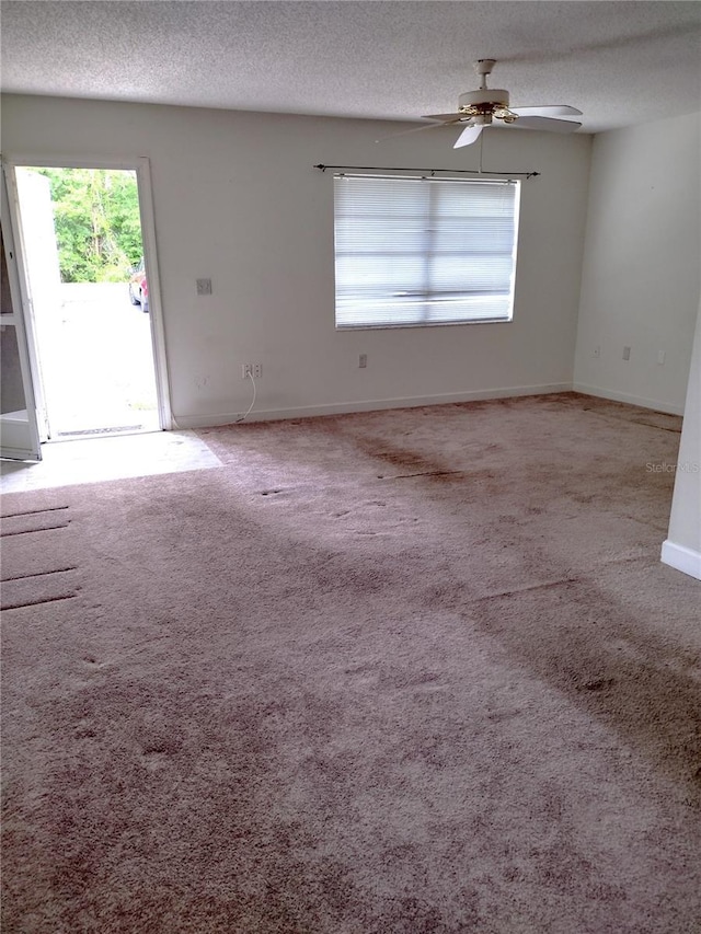 11715 Boynton Ln Unit 74B, New Port Richey, FL 34654 - unfurnished living room featuring a textured ceiling, carpet flooring, a ceiling fan, and baseboards