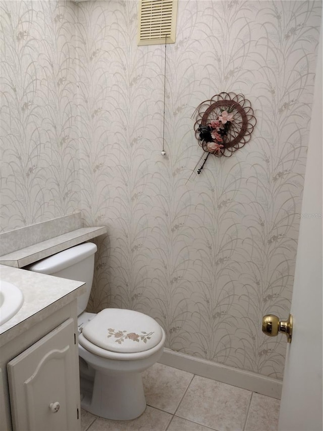 11715 Boynton Ln Unit 74B, New Port Richey, FL 34654 - half bathroom with wallpapered walls, vanity, toilet, tile patterned flooring, and baseboards