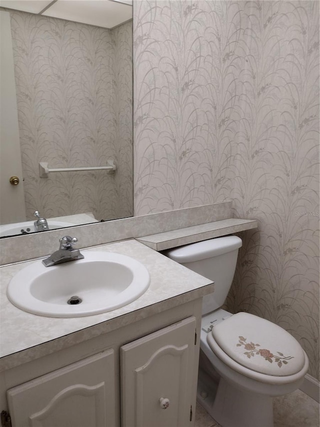 11715 Boynton Ln Unit 74B, New Port Richey, FL 34654 - half bathroom with vanity, toilet, and wallpapered walls