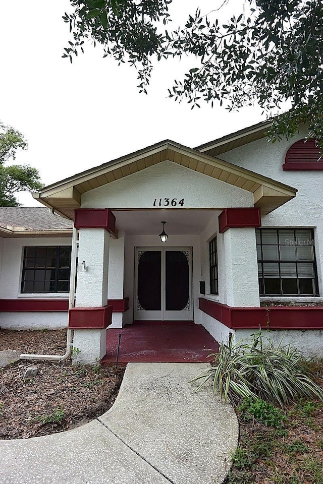 11364 Orangewood Ct, Spring Hill, FL 34609 - view of exterior entry featuring covered porch and stucco siding