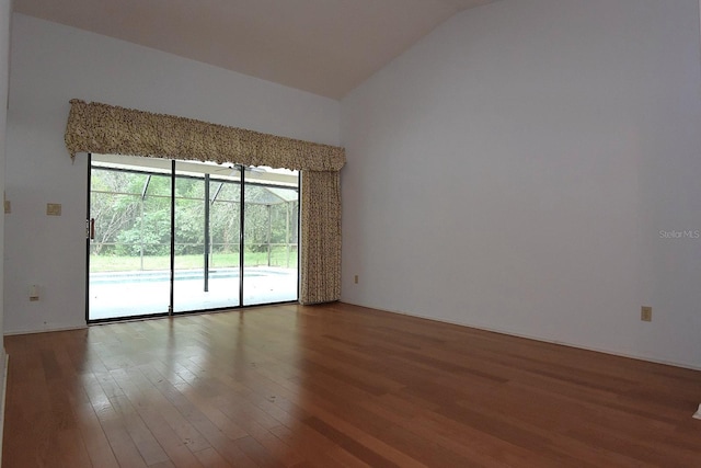 11364 Orangewood Ct, Spring Hill, FL 34609 - empty room featuring wood finished floors and vaulted ceiling