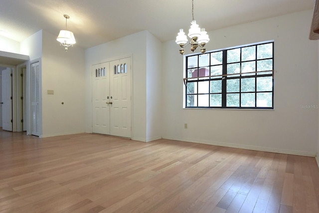 11364 Orangewood Ct, Spring Hill, FL 34609 - foyer featuring light wood-style floors, a chandelier, and baseboards
