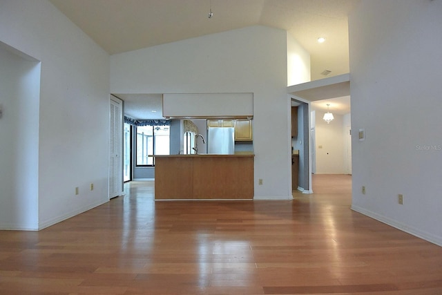 11364 Orangewood Ct, Spring Hill, FL 34609 - unfurnished living room featuring light wood-style flooring, baseboards, and high vaulted ceiling