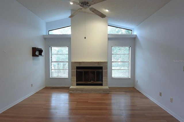 11364 Orangewood Ct, Spring Hill, FL 34609 - unfurnished living room featuring ceiling fan, a glass covered fireplace, wood finished floors, baseboards, and high vaulted ceiling