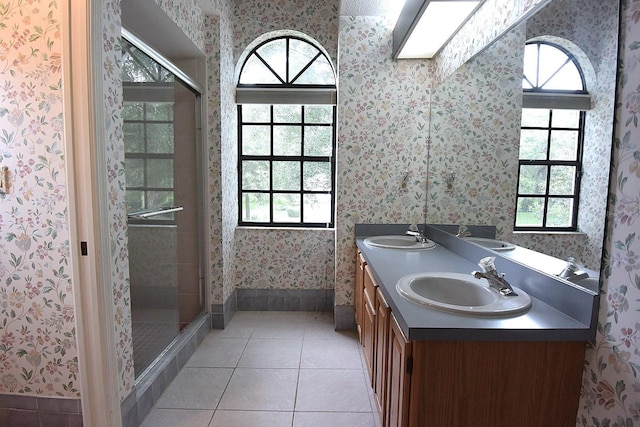 11364 Orangewood Ct, Spring Hill, FL 34609 - bathroom featuring wallpapered walls, double vanity, a stall shower, tile patterned flooring, and baseboards