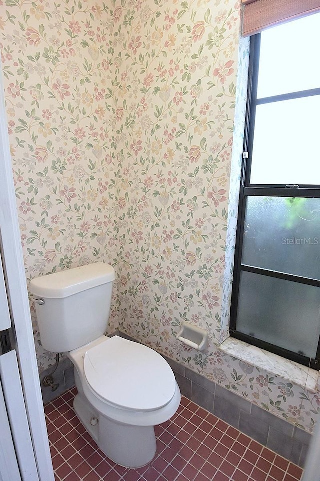11364 Orangewood Ct, Spring Hill, FL 34609 - bathroom with wallpapered walls, toilet, and tile patterned floors