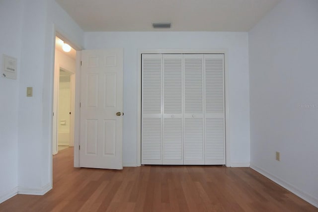 11364 Orangewood Ct, Spring Hill, FL 34609 - unfurnished bedroom featuring wood finished floors, baseboards, and a closet