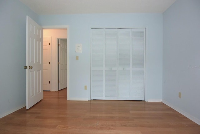 11364 Orangewood Ct, Spring Hill, FL 34609 - unfurnished bedroom featuring wood finished floors, baseboards, and a closet
