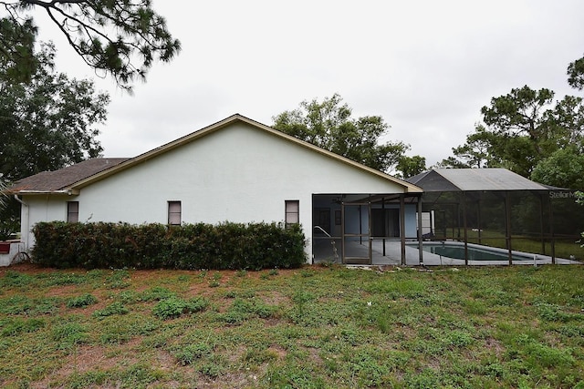 11364 Orangewood Ct, Spring Hill, FL 34609 - back of property with stucco siding, a yard, an outdoor pool, and glass enclosure