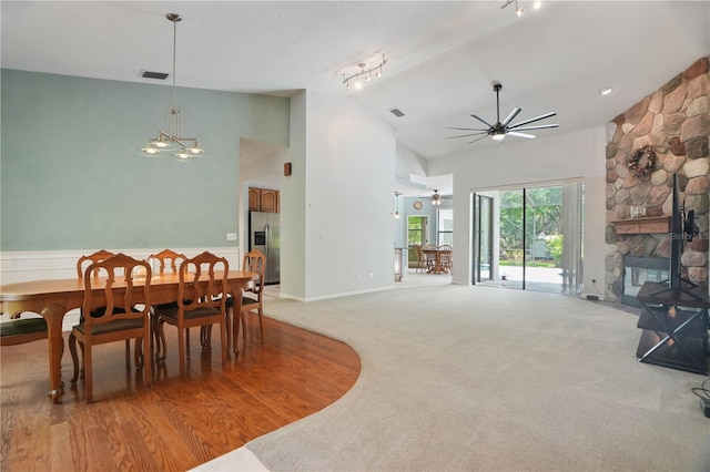 8518 Quail Hollow Blvd, Wesley Chapel, FL 33544 - dining area featuring ceiling fan, high vaulted ceiling, a stone fireplace, wainscoting, and track lighting