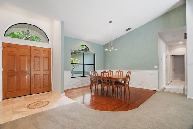 8518 Quail Hollow Blvd, Wesley Chapel, FL 33544 - foyer featuring a chandelier, high vaulted ceiling, plenty of natural light, carpet, and wainscoting